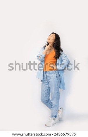 Thoughtful Asian woman posing full boby against white background.