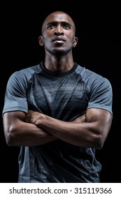 Thoughtful Athlete With Arms Crossed Standing Against Black Background