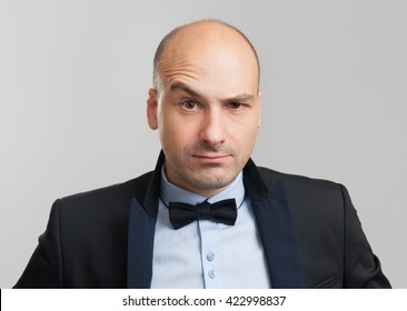 Thoughtful Bald Business Man With A Raised Eyebrow