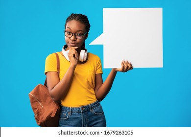 Thoughtful Black Student Girl Showing Empty Speech Bubble Thinking About Something Posing Over Blue Studio Background. Mockup