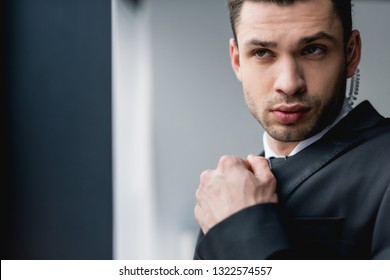 Thoughtful Bodyguard In Suit Using Earphone 