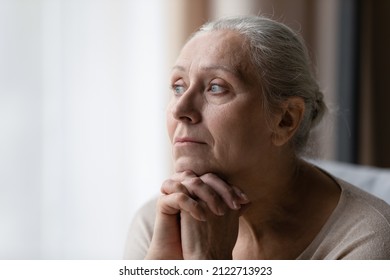 Thoughtful bored older 70s woman looking at window, feeling depressed, frustrated, lonely, suffering form memory loss, dementia, Alzheimer disease, mental disorder. Old age problems concept - Shutterstock ID 2122713923