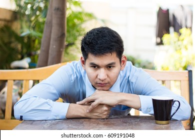 Thoughtful Business Man Sitting On Wooden Bench With Coffee Cup Thinking Something Concentrate