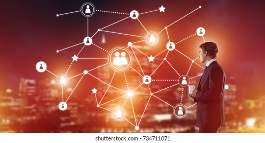 Thoughtful businessman against night cityscape working with social connection media concept - Shutterstock ID 734711071