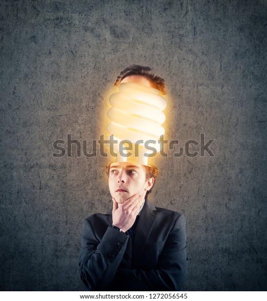 Thoughtful businessman with his head divided have\
an lightbulb inside.