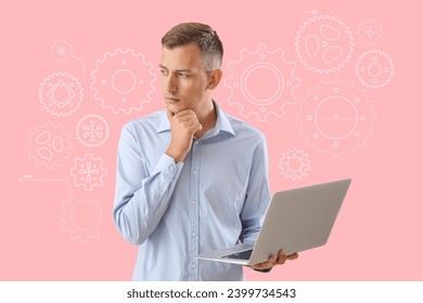 Thoughtful businessman with laptop and drawn gears on pink background - Powered by Shutterstock