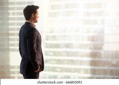 Thoughtful businessman looking at city standing near window, successful entrepreneur considering new opportunity, thinking over business improvement, ways to overcome obstacles, side view, copy space  - Powered by Shutterstock