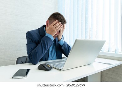 Thoughtful businessman looking at his laptop. a tired employee at work in front of a computer monitor. annoying work. A sad businessman. Tired eyesight from working on a laptop. - Shutterstock ID 2069129699