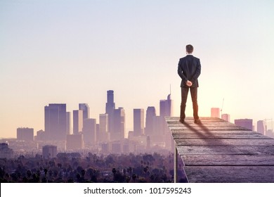Thoughtful businessman on abstract city background. Research and employment concept - Shutterstock ID 1017595243