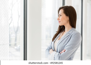 Thoughtful businesswoman looking through window in office
