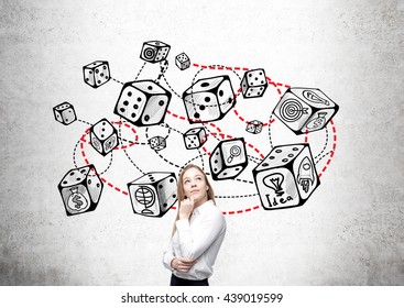 Thoughtful businesswoman standing against concrete wall with connected dice sketch. Game and probability theory - Shutterstock ID 439019599