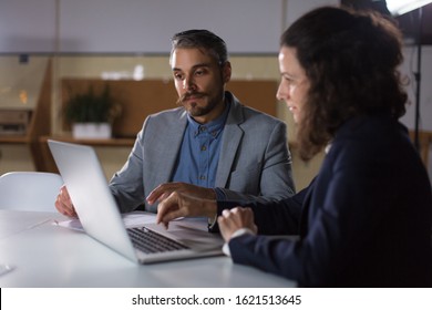 Thoughtful confident colleagues working with laptop in office. Concentrated business partners discussing business questions. Business, working late concept - Shutterstock ID 1621513645