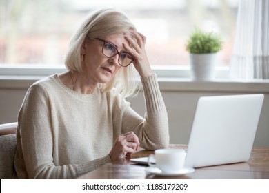 Thoughtful confused mature business woman concerned thinking about online problem looking at laptop, frustrated worried senior middle aged female reading bad email news, suffering from memory loss