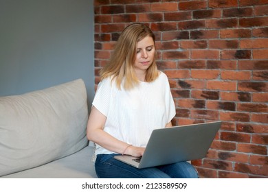 Thoughtful Cute Woman In Casual Wear Sitting With Computer On Sofa, Can't Focus On Work, Needs Rest, Feeling Bored, Need Extra Motivation, Working Remotely At Home