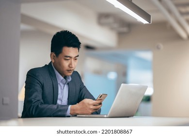 Thoughtful Doubtful Chinese Businessman In Tension Sitting At Workplace Desk Near Laptop Distracted From Work Makes Difficult Decision Looking At Laptop Feels Uncertain Thinking Over Problem Solution