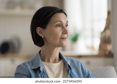 Thoughtful dreamy attractive middle aged lady enjoying calm leisure time at home, looking away in deep thoughts with pensive face, dreaming, thinking over good future plans - Powered by Shutterstock