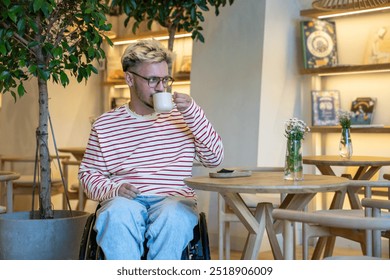 Thoughtful dreamy man in wheelchair drinking coffee at cafe table. Modern man gazing at door, waiting for friend, anticipating meeting in coffee shop alone. Tranquill lifestyle on weekends - Powered by Shutterstock