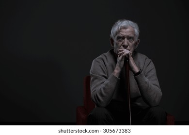 Thoughtful Elder Man Sitting In A Dark Room