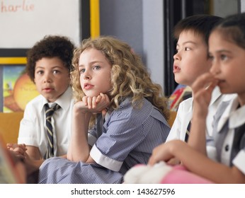 Thoughtful elementary students sitting in classroom