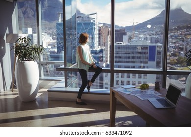 Thoughtful Executive Looking Through Window In Office