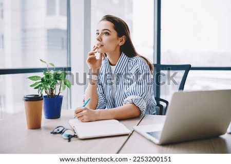 Thoughtful female rewriter in smart casual clothing sitting at table desktop with laptop computer and working with ideas for SEO text,pensive content manager planning project organisation in workspace
