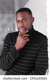 Thoughtful Fit Muscular Black Man In Sweater With Turtle Neck Leaning To The Wall. Domestic Photo At Home. People Lifestyle Concept. Handsome Black Man's Portrait. Male Self-Confidence Concept