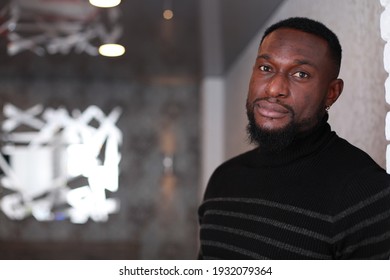 Thoughtful Fit Muscular Black Man In Sweater With Turtle Neck Leaning To The Wall. Domestic Photo At Home. People Lifestyle Concept. Handsome Black Man's Portrait. Male Self-Confidence Concept