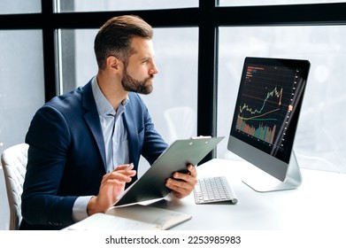 Thoughtful focused successful caucasian male stock investor, broker, financial adviser, sits at work desk, looks at computer, pensively analyze risks and prospects, rise or fall of cryptocurrency coin - Shutterstock ID 2253985983