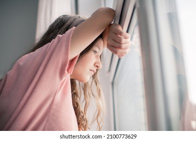 Thoughtful girl looking at window, sad depressed teenager spending time alone at home, young upset pensive woman feeling lonely or frustrated thinking about problems - Powered by Shutterstock