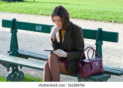 Thoughtful girl reading outside on a bench