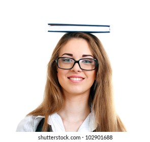 Thoughtful happy woman in glasses carrying book on her head and trying to balance it