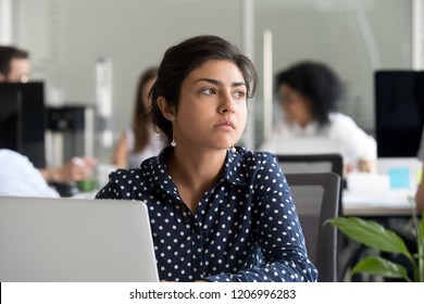 Thoughtful Indian Business Woman Looking Away Feeling Bored Pensive Thinking Of Problem Solution In Office With Laptop, Serious Hindu Employee Searching New Ideas At Work Unmotivated About Dull Job