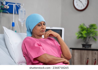 Thoughtful indian cancer patient deep thinking while sitting on bed at hospital - concept of loneliness, treatment and emotional concern. - Powered by Shutterstock