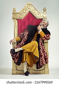 The thoughtful king. Studio shot of a richly garbed king sitting on a throne. - Shutterstock ID 2167990569