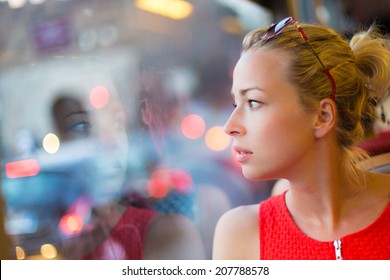 Thoughtful lady riding on a tram and looking out the window.  - Powered by Shutterstock