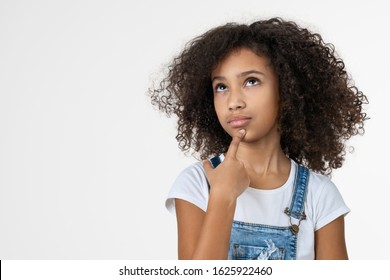 Thoughtful little girl child touching chin with finger thinking isolated on white studio background