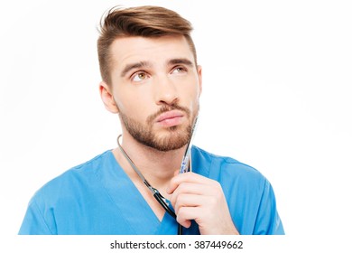 Thoughtful Male Doctor Looking Up Isolated On A White Background