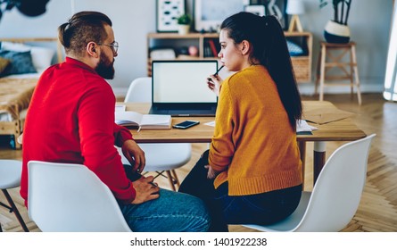 Thoughtful Male And Female Students Sitting At Desktop With Laptop Computer Communicating About Learning For Exam Indoors, Marriage Having Serious Discussion Planning Money Budget At Home Interior
