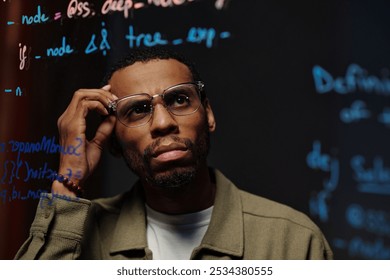 Thoughtful Man Analyzing Data on Transparent Board - Powered by Shutterstock