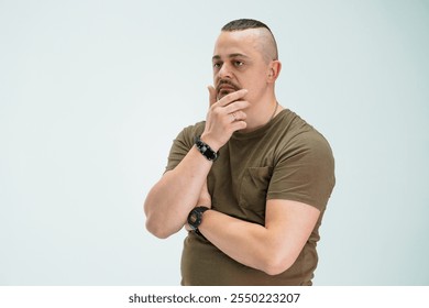 Thoughtful man in casual clothing contemplating an idea with a pensive expression. - Powered by Shutterstock