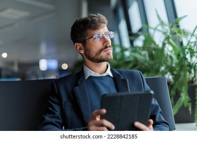 thoughtful man with a digital tablet in the airport waiting room . - Powered by Shutterstock