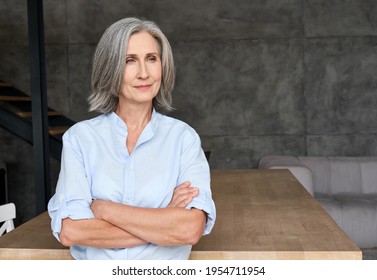 Thoughtful mature 60s old woman standing arms crossed in home office. Portrait of senior adult professional ceo or financial director woman in corporate photoshoot looking in future vision. - Shutterstock ID 1954711954