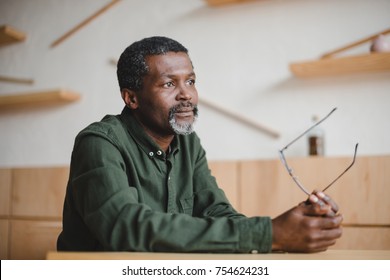 thoughtful mature african american man sitting in cafe
