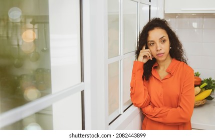 Thoughtful Mature Woman
Concept : Portrait Latino Housewife Stands In The Kitchen Contemplating Something Deep In Her Kitchen, Thinking About Making An Upcoming Family Dinner.