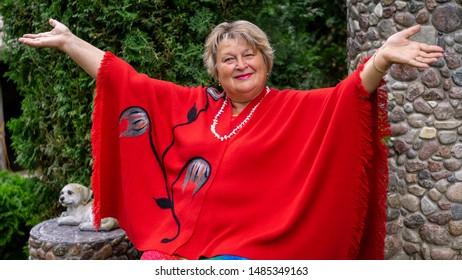 Thoughtful Mature Woman In Red In The City Park Spread Her Arms