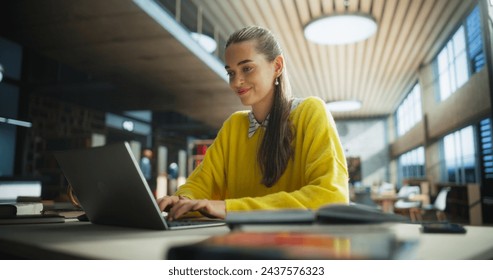 Thoughtful Multiethnic College Student Using Laptop Computer to Study in a Public Library. Beautiful Young Woman Learning Online, Getting Ready for Exams, Browsing Internet to Prepare for Class - Powered by Shutterstock