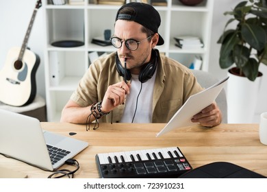 Thoughtful Musician Looking At Laptop While Working On Project