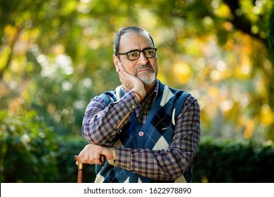 Thoughtful old man sitting on park alone