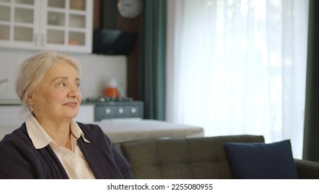 The thoughtful old woman was at home alone in thought. Loneliness grief concept. A woman alone at home feels uneasy when she looks at the empty advertising space on the right of the screen. - Shutterstock ID 2255080955