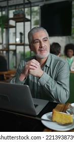 Thoughtful Older Businessman Seated At Coffee Shop In Contemplation. Pensive Senior Executive Thinking About Business Looking Out Window In Vertical Video SS